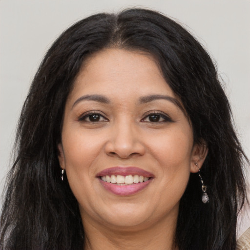 Joyful latino adult female with long  brown hair and brown eyes