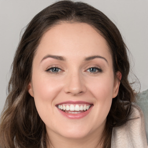 Joyful white young-adult female with long  brown hair and brown eyes