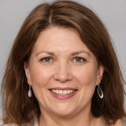 Joyful white adult female with medium  brown hair and grey eyes