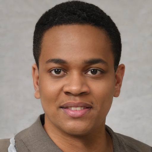 Joyful black young-adult male with short  black hair and brown eyes