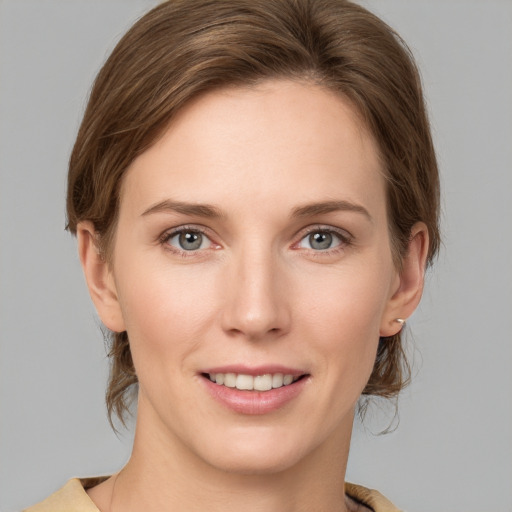 Joyful white young-adult female with medium  brown hair and grey eyes