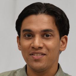 Joyful latino young-adult male with short  black hair and brown eyes