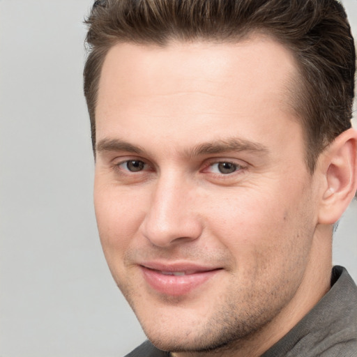 Joyful white young-adult male with short  brown hair and grey eyes