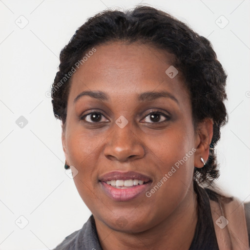 Joyful black adult female with long  brown hair and brown eyes