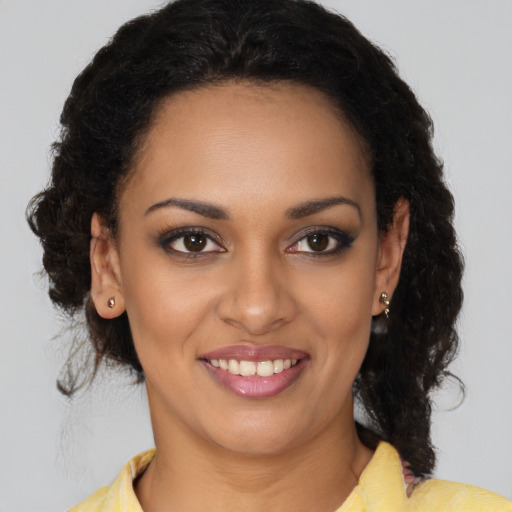 Joyful black young-adult female with long  brown hair and brown eyes