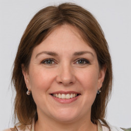 Joyful white adult female with medium  brown hair and grey eyes