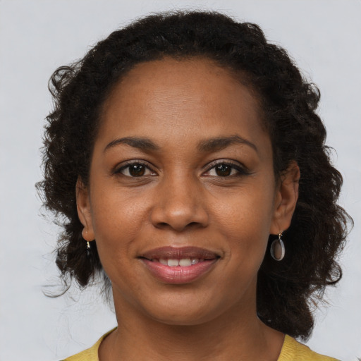 Joyful black young-adult female with short  brown hair and brown eyes