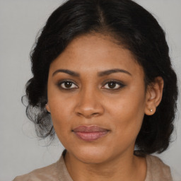 Joyful black young-adult female with long  brown hair and brown eyes