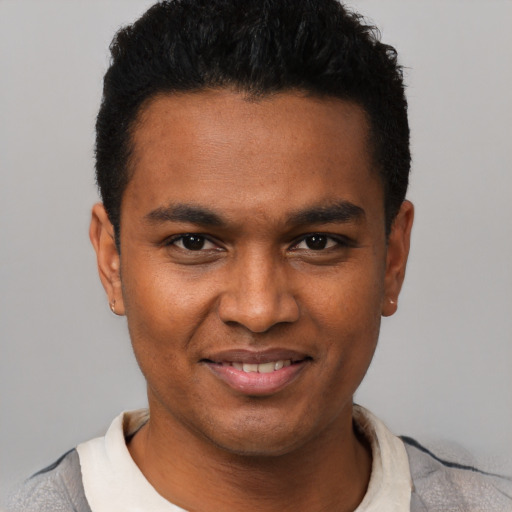 Joyful black young-adult male with short  black hair and brown eyes