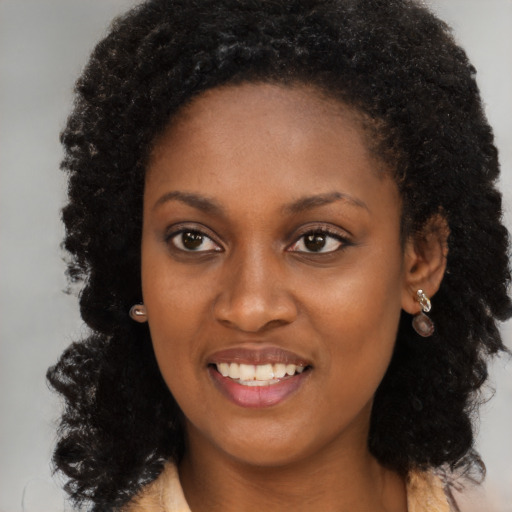 Joyful black young-adult female with long  black hair and brown eyes