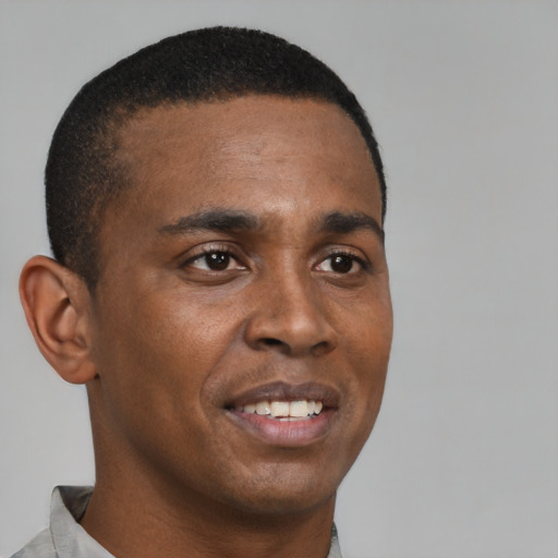 Joyful black young-adult male with short  brown hair and brown eyes