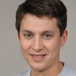 Joyful white adult male with short  brown hair and brown eyes