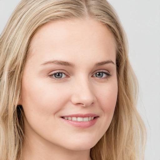 Joyful white young-adult female with long  brown hair and blue eyes