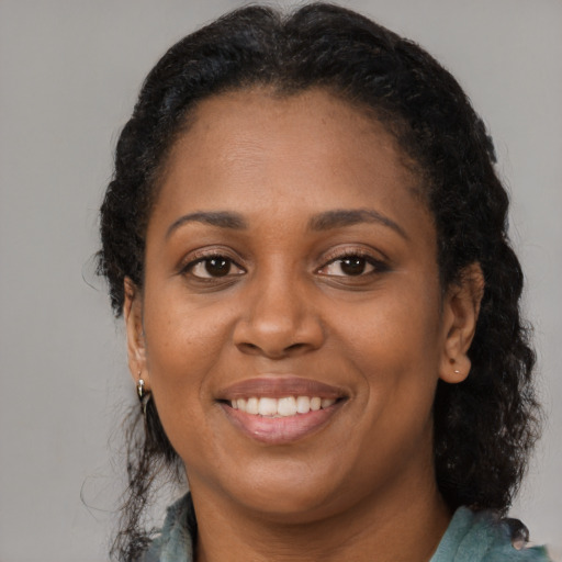 Joyful latino adult female with long  brown hair and brown eyes