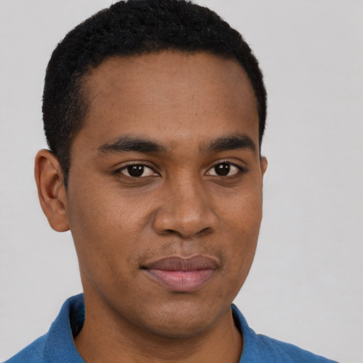 Joyful black young-adult male with short  black hair and brown eyes