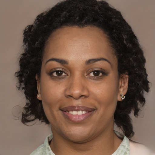 Joyful black young-adult female with medium  brown hair and brown eyes