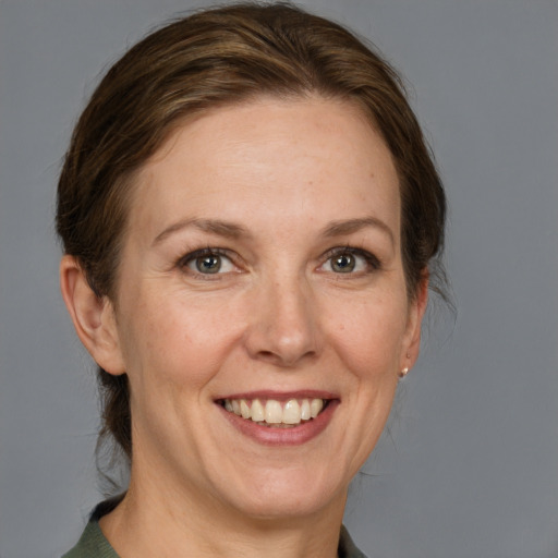 Joyful white adult female with medium  brown hair and grey eyes