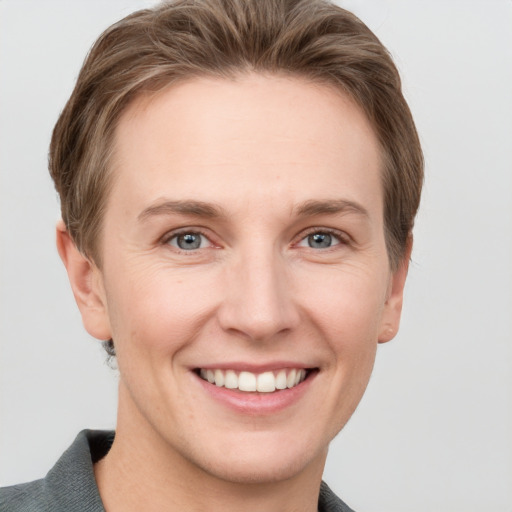 Joyful white young-adult female with short  brown hair and grey eyes