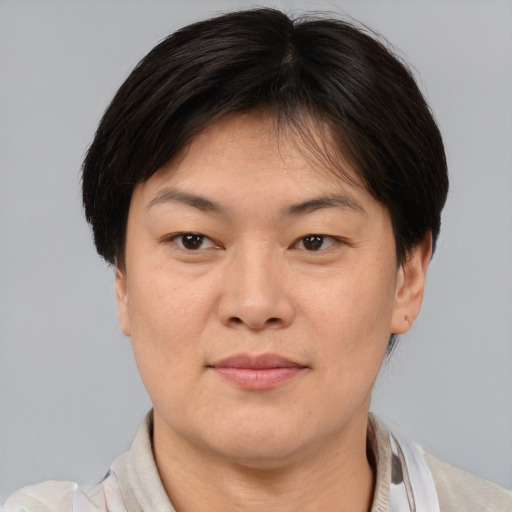 Joyful asian adult female with short  brown hair and brown eyes