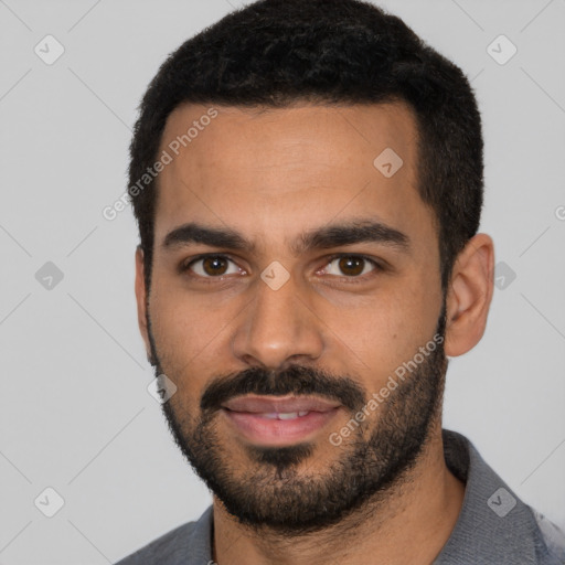 Joyful latino young-adult male with short  black hair and brown eyes