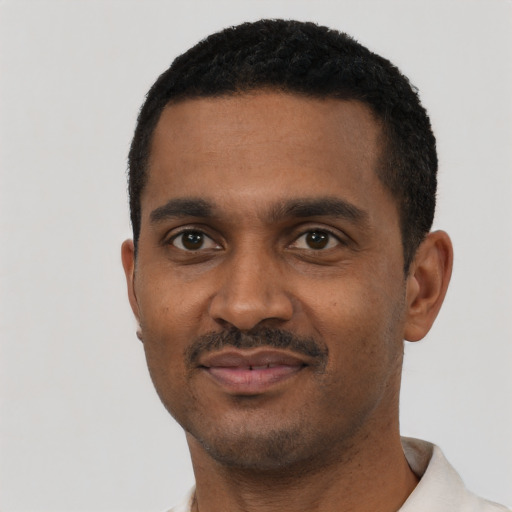 Joyful black young-adult male with short  black hair and brown eyes