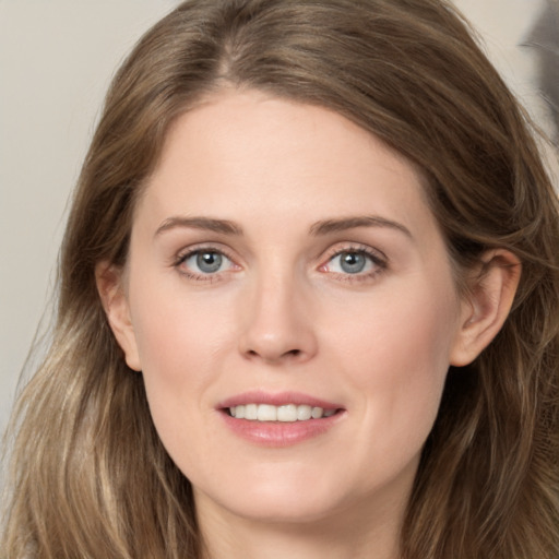 Joyful white young-adult female with long  brown hair and grey eyes