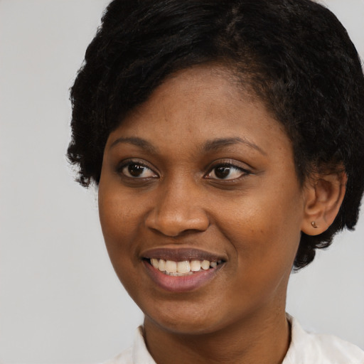 Joyful black young-adult female with short  black hair and brown eyes