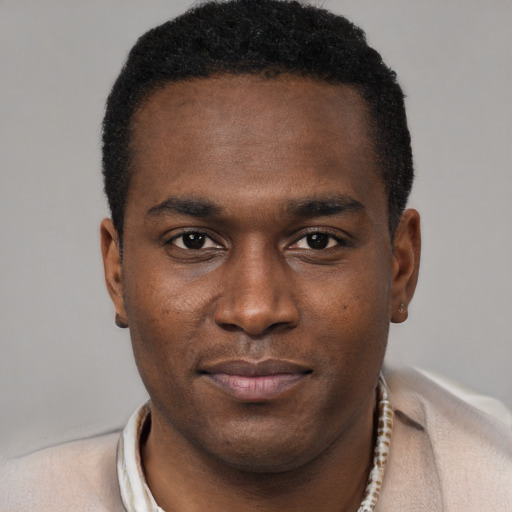 Joyful black young-adult male with short  black hair and brown eyes