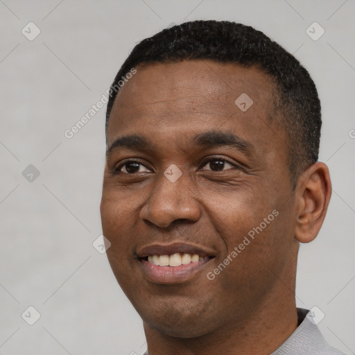 Joyful black young-adult male with short  black hair and brown eyes