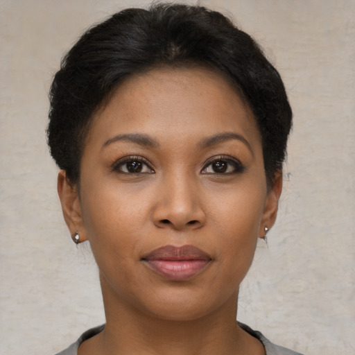 Joyful black young-adult female with short  brown hair and brown eyes