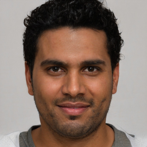 Joyful latino young-adult male with short  brown hair and brown eyes