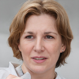 Joyful white adult female with medium  brown hair and grey eyes