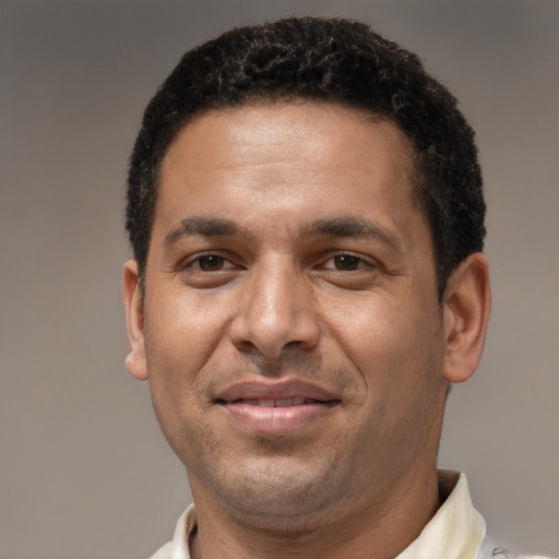 Joyful latino adult male with short  brown hair and brown eyes