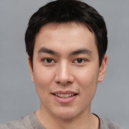 Joyful asian young-adult male with short  brown hair and brown eyes