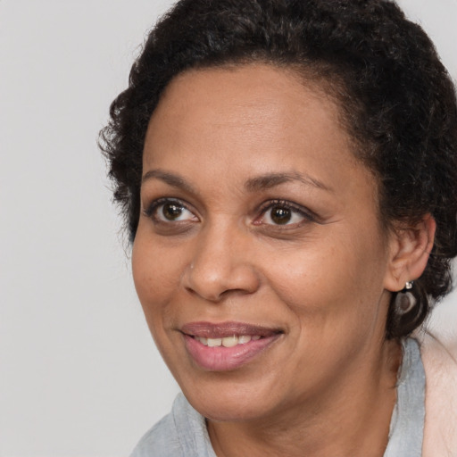 Joyful black adult female with medium  brown hair and brown eyes