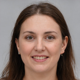 Joyful white young-adult female with long  brown hair and grey eyes