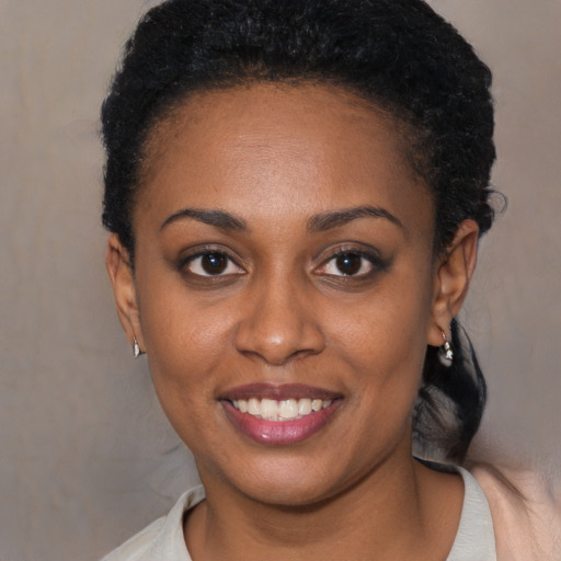 Joyful black young-adult female with short  black hair and brown eyes