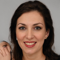 Joyful white adult female with long  brown hair and brown eyes