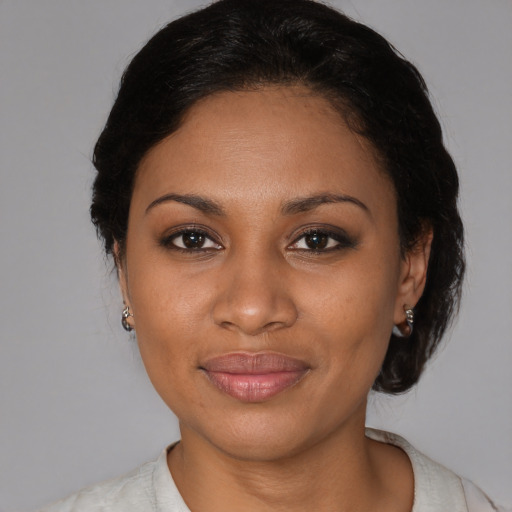 Joyful black young-adult female with medium  brown hair and brown eyes