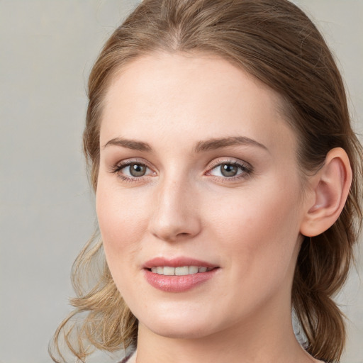 Joyful white young-adult female with medium  brown hair and blue eyes