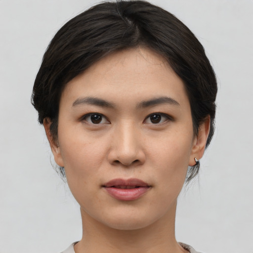 Joyful asian young-adult female with short  black hair and brown eyes