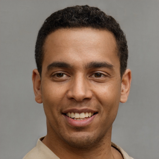 Joyful latino young-adult male with short  brown hair and brown eyes