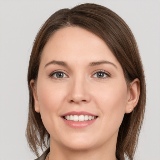 Joyful white young-adult female with medium  brown hair and grey eyes