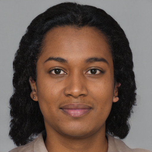 Joyful black young-adult female with long  black hair and brown eyes