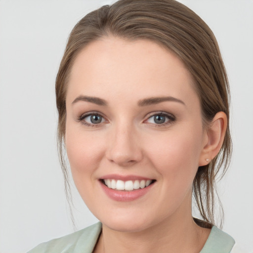 Joyful white young-adult female with medium  brown hair and blue eyes