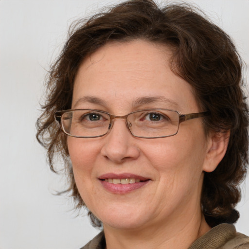 Joyful white adult female with medium  brown hair and blue eyes