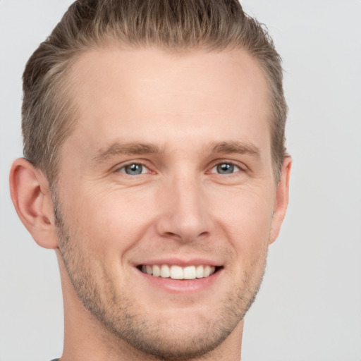 Joyful white adult male with short  brown hair and grey eyes