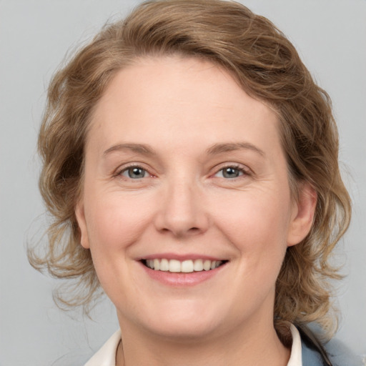 Joyful white adult female with medium  brown hair and blue eyes