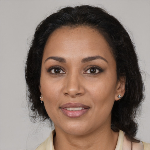 Joyful latino adult female with medium  brown hair and brown eyes