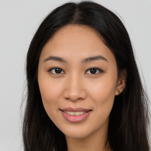 Joyful asian young-adult female with long  brown hair and brown eyes
